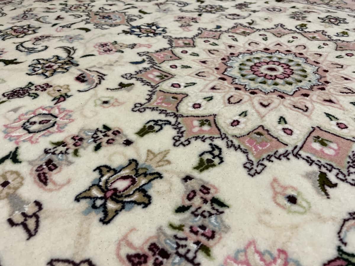 Persian rug of Tabriz style in dimensions 208 centimeters length by 134 centimeters width with mainly beige and pink colors — Texture close-up