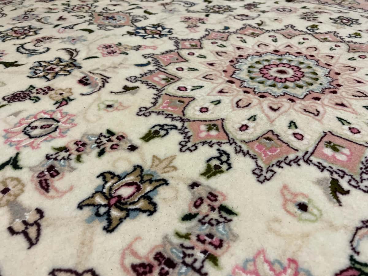 persischer Teppich im Tabriz Stil in den Maßen 208 Zentimeter Länge mal 134 Zentimeter Breite mit überwiegend beige und rosa Farben — Nahaufnahme der Textur