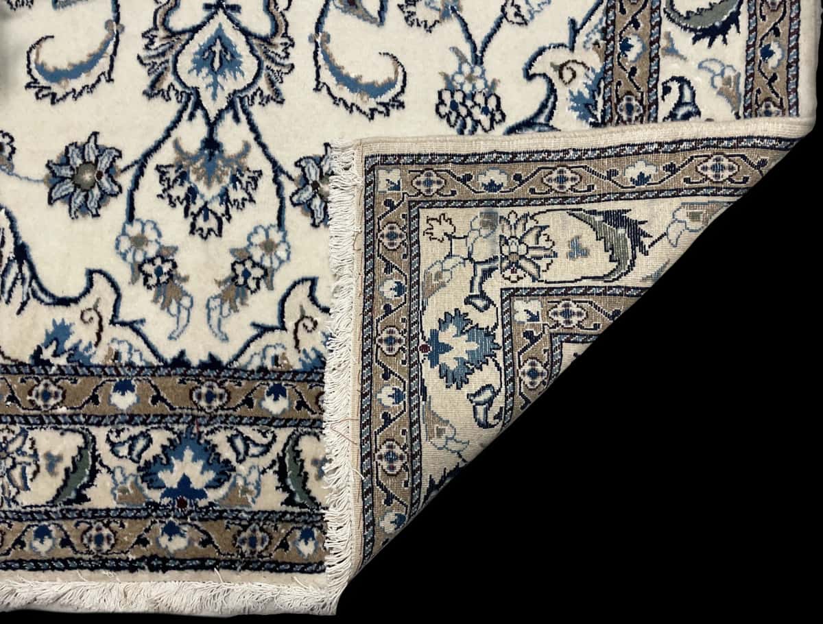 alfombra persa de estilo Nain en dimensiones 202 centímetros de largo por 147 centímetros de ancho con colores principalmente blanco y beige — Plegada
