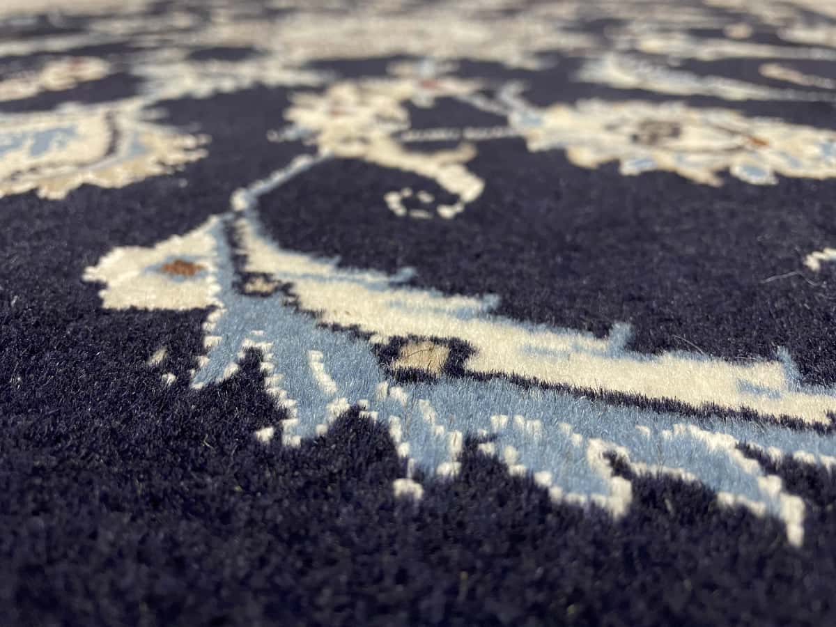 Persian rug of Nain style in dimensions 150 centimeters length by 98 centimeters width with mainly blue colors — Texture close-up