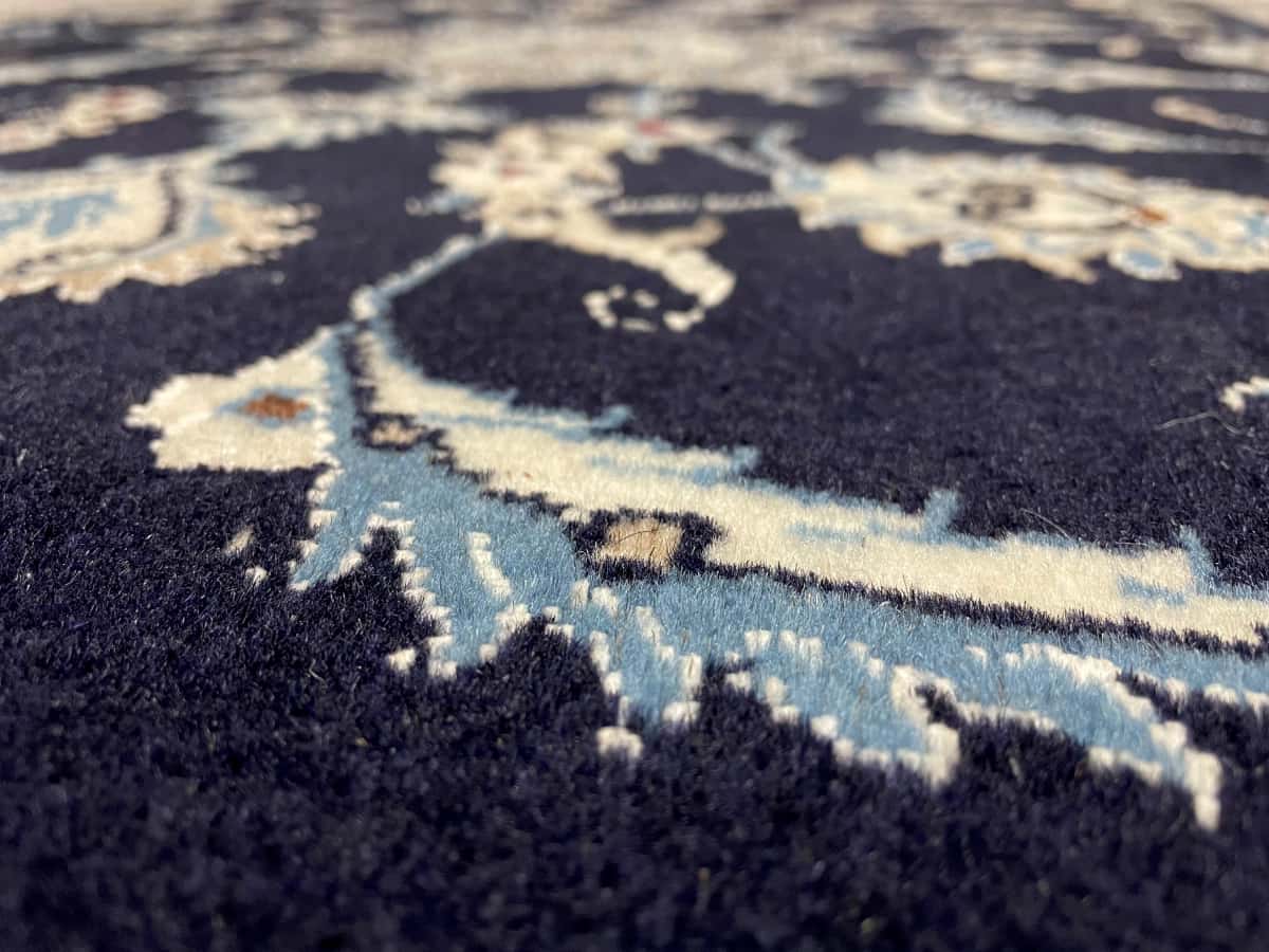 persischer Teppich im Nain Stil in den Maßen 150 Zentimeter Länge mal 98 Zentimeter Breite mit überwiegend blau Farben — Nahaufnahme der Textur