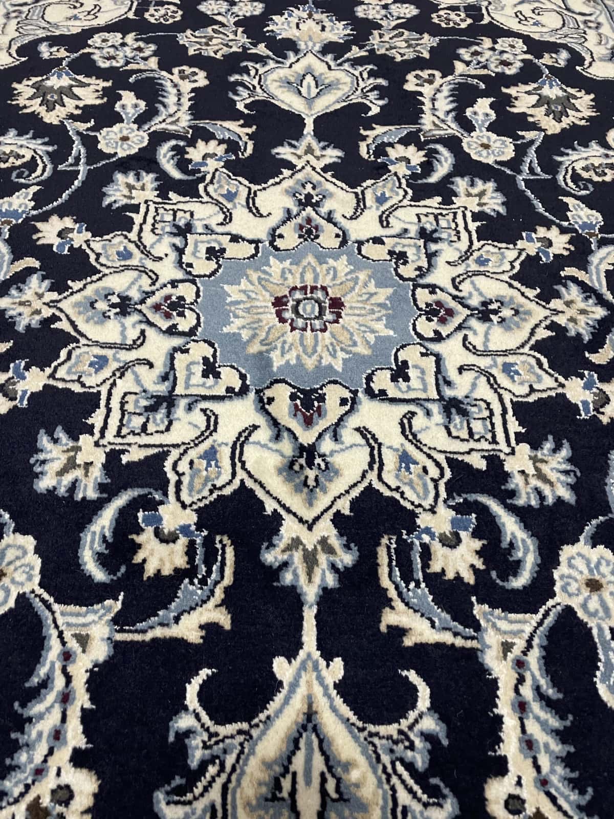 Persian rug of Nain style in dimensions 204 centimeters length by 125 centimeters width with mainly blue colors — Texture close-up