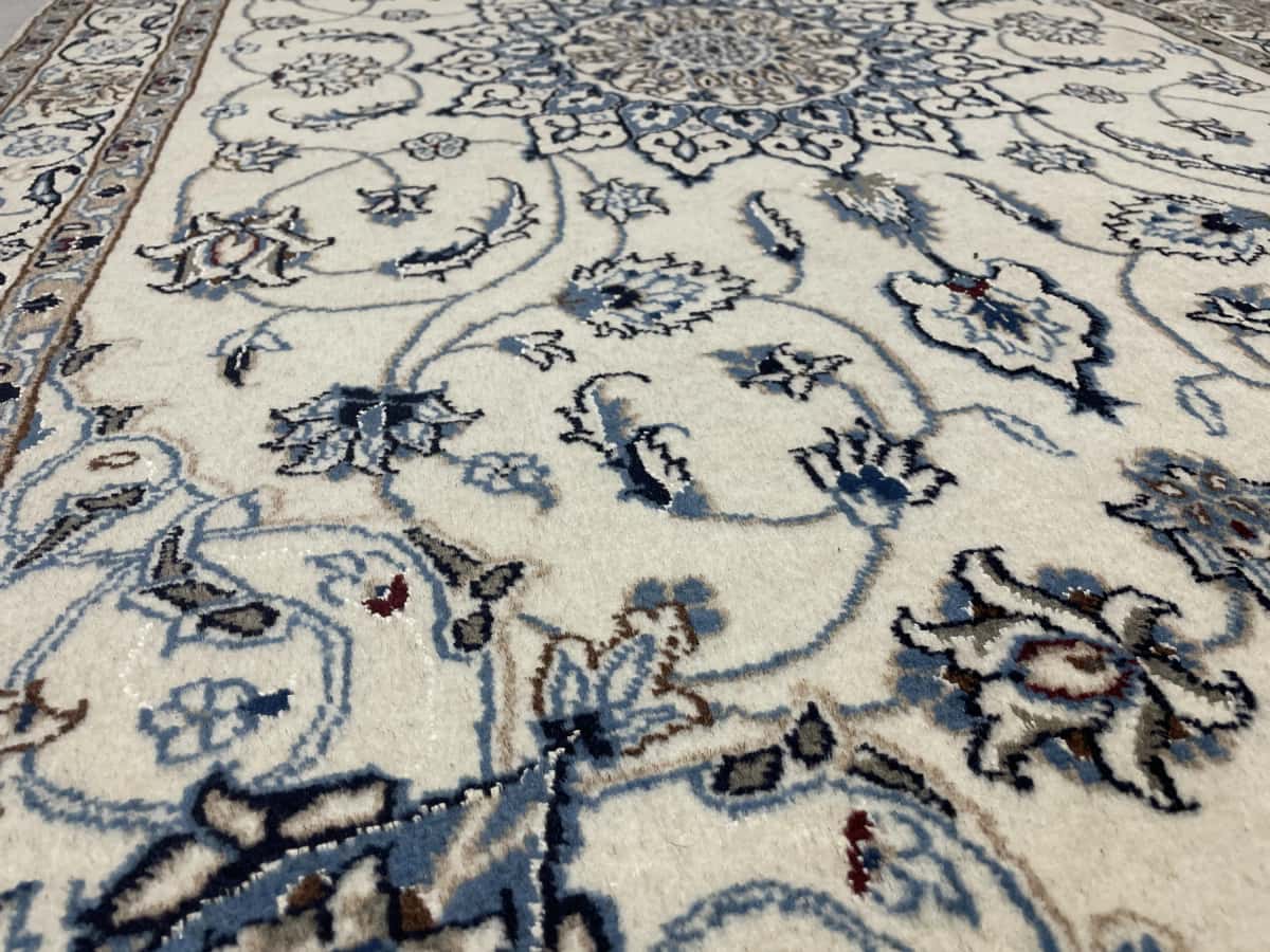 Persian rug of Nain style in dimensions 202 centimeters length by 120 centimeters width with mainly beige and blue colors — Texture close-up