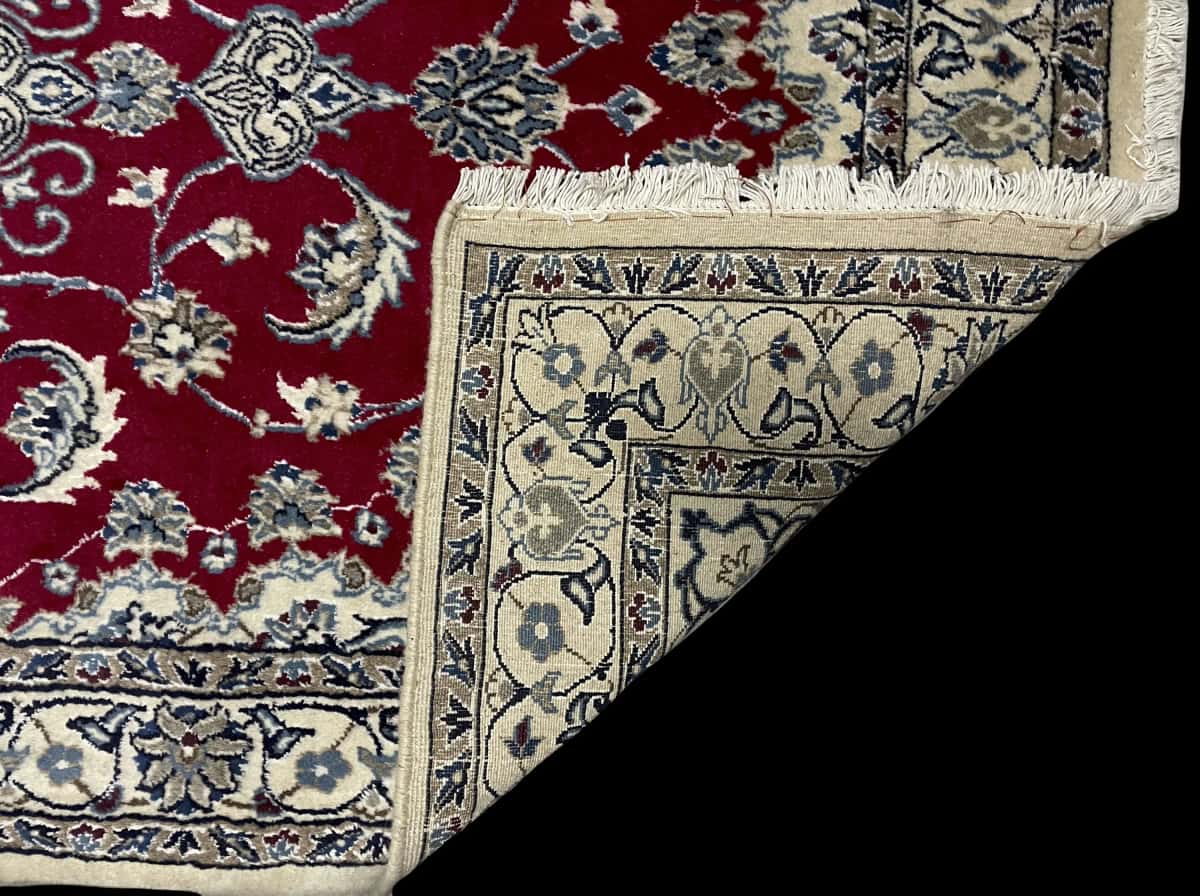 Persian rug of Nain style in dimensions 205 centimeters length by 117 centimeters width with mainly red colors — Folded