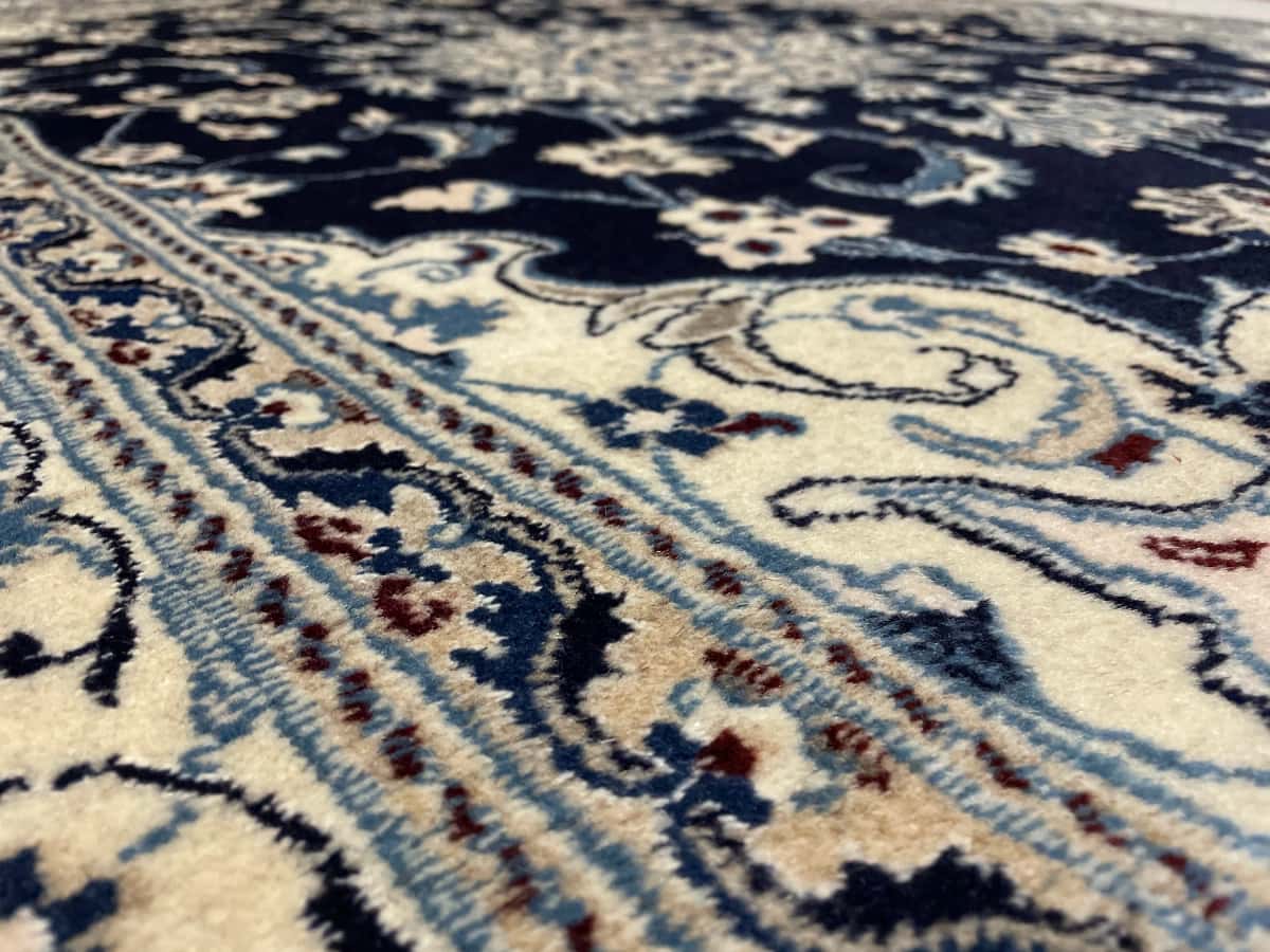 Persian rug of Nain style in dimensions 204 centimeters length by 148 centimeters width with mainly blue colors — Texture close-up