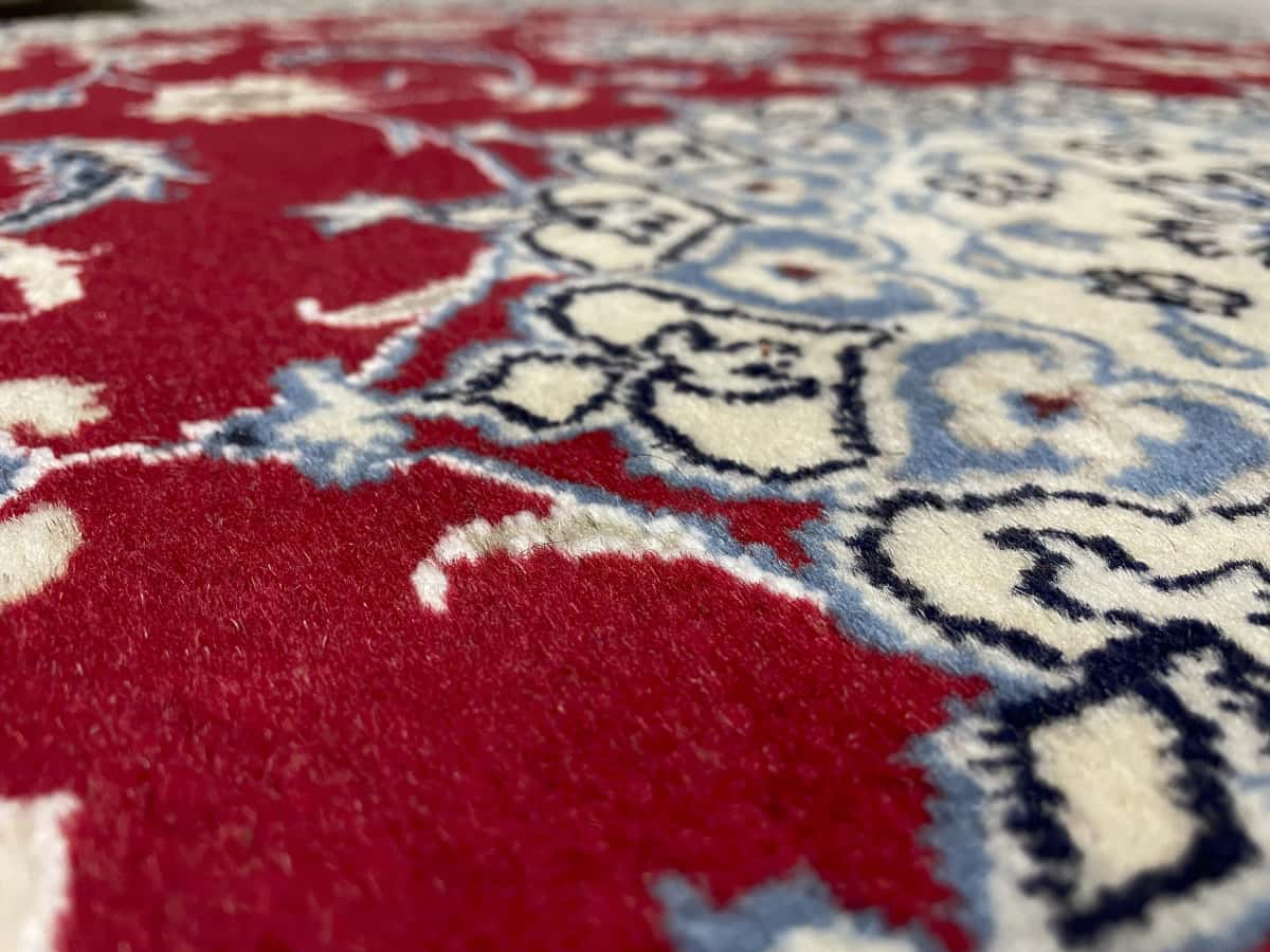 alfombra persa de estilo Nain en dimensiones 200 centímetros de largo por 118 centímetros de ancho con colores principalmente rojo — Primer plano de la textura