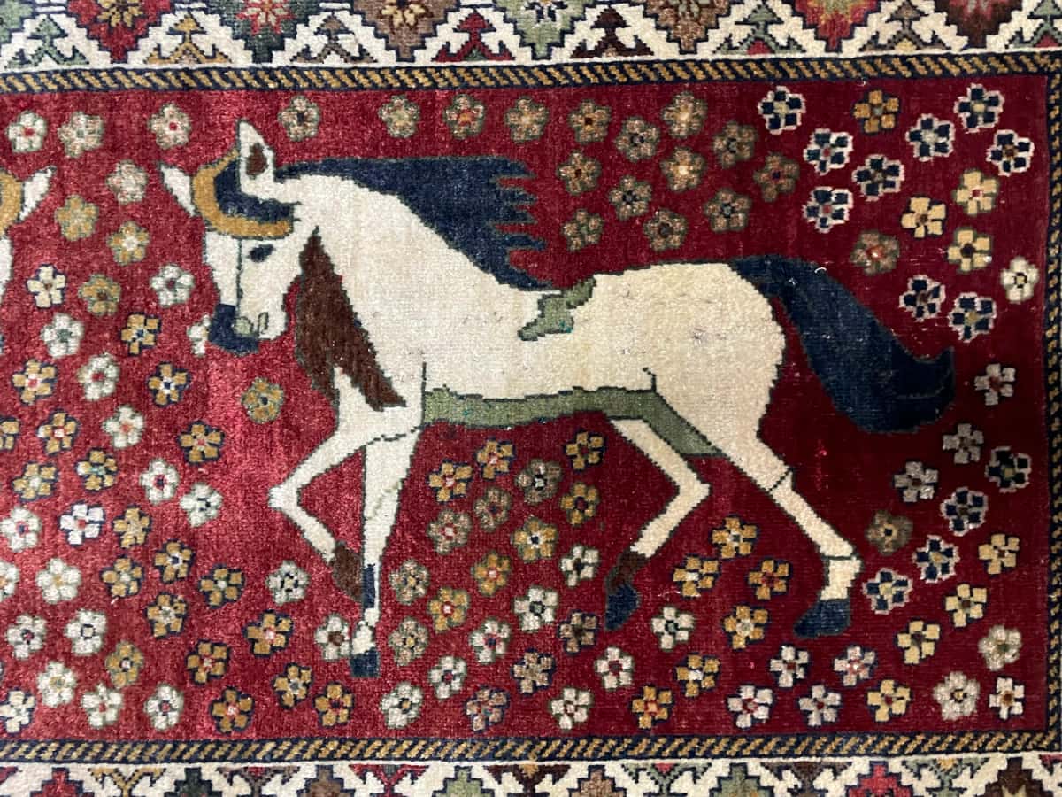 alfombra persa de estilo gabbeh en dimensiones 203 centímetros de largo por 96 centímetros de ancho con colores principalmente rojo — Primer plano de la textura