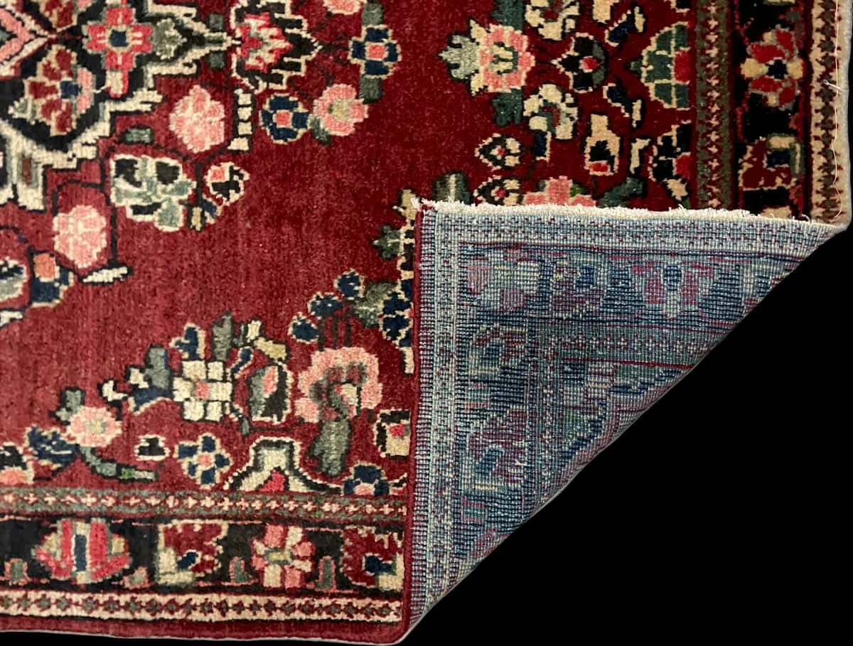 persischer Teppich im Arak Stil in den Maßen 204 Zentimeter Länge mal 126 Zentimeter Breite mit überwiegend rot Farben — Gefaltet