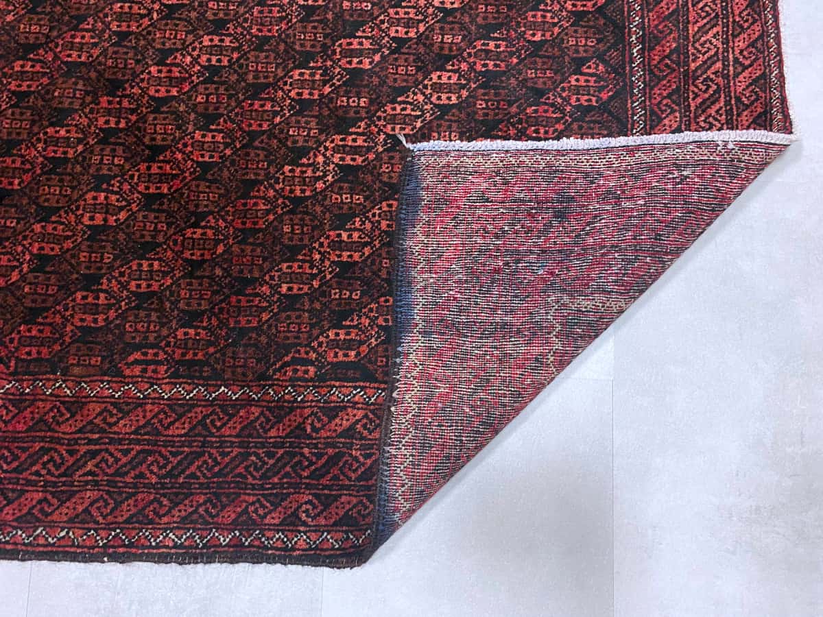 persischer Teppich in den Maßen 186 Zentimeter Länge mal 97 Zentimeter Breite mit überwiegend rot und braun Farben — Gefaltet
