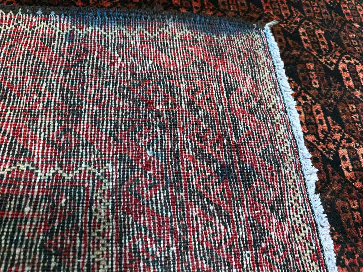 persischer Teppich in den Maßen 186 Zentimeter Länge mal 97 Zentimeter Breite mit überwiegend rot und braun Farben — Knotendetail