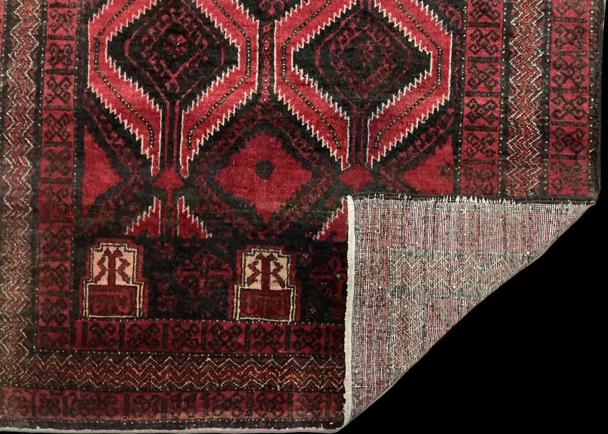 Persian rug of Baluch style in dimensions 184 centimeters length by 105 centimeters width with mainly red colors — Folded