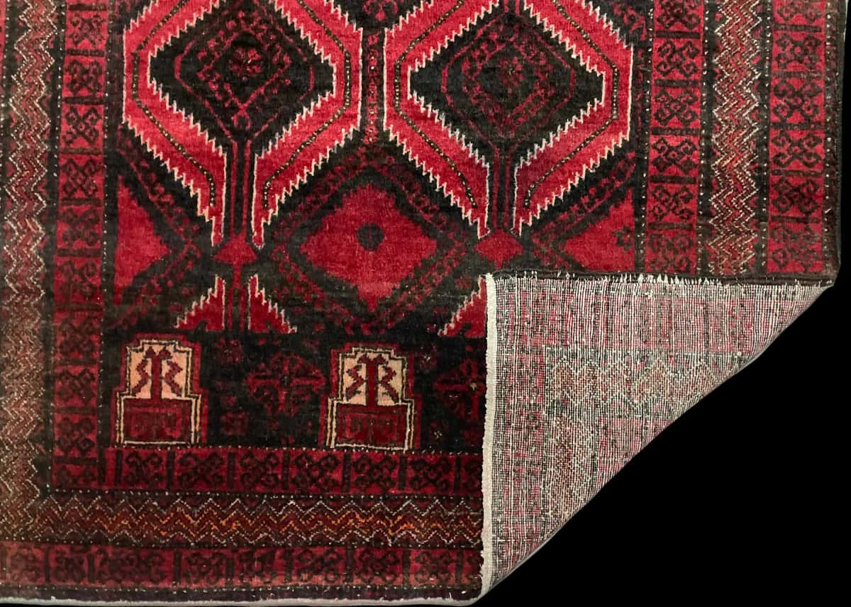 Persian rug of Baluch style in dimensions 184 centimeters length by 105 centimeters width with mainly red colors — Folded