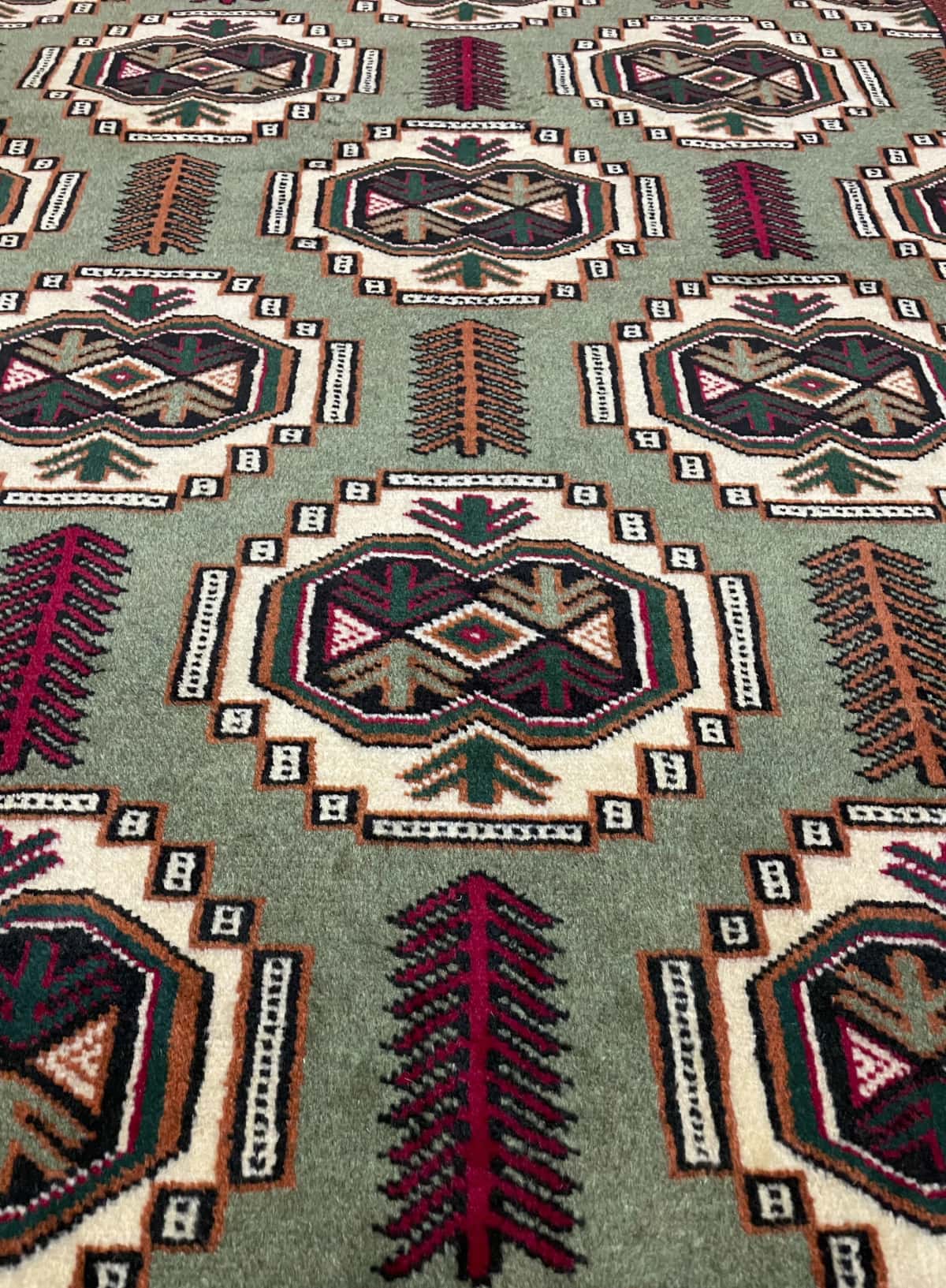Persian rug of Turkoman style in dimensions 193 centimeters length by 130 centimeters width with mainly red and green colors — Texture close-up