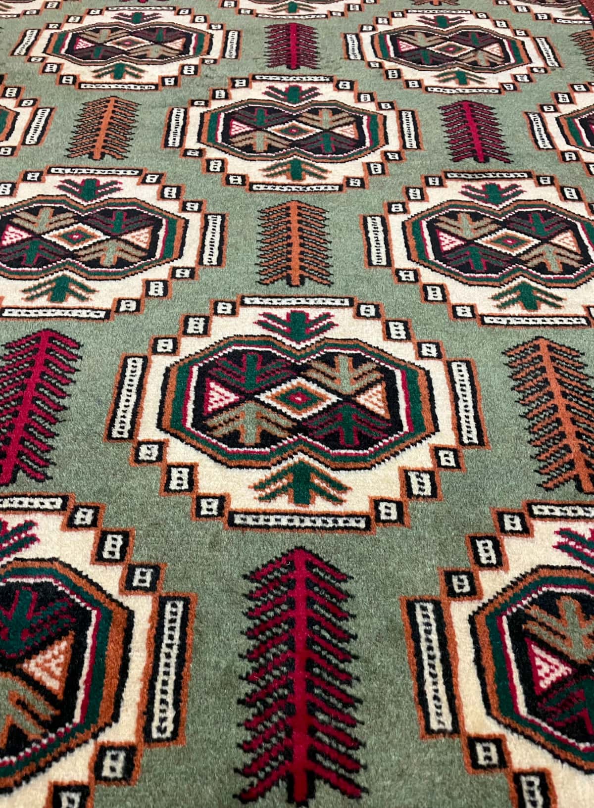 persischer Teppich im turkmenischer Stil in den Maßen 193 Zentimeter Länge mal 130 Zentimeter Breite mit überwiegend rot und grün Farben — Nahaufnahme der Textur