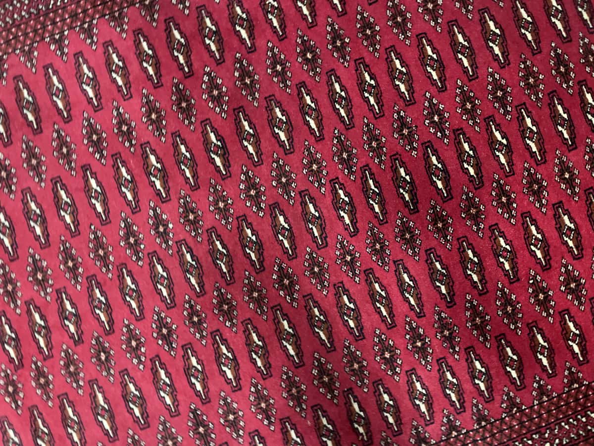 Persian rug of Turkoman style in dimensions 196 centimeters length by 132 centimeters width with mainly red colors — Texture close-up
