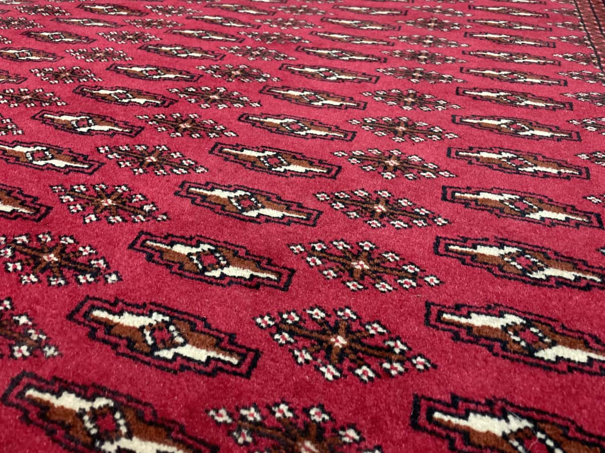 Persian rug of Turkoman style in dimensions 196 centimeters length by 132 centimeters width with mainly red colors — Texture close-up