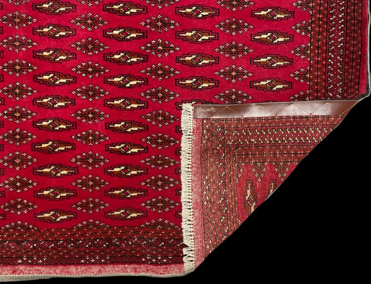 persischer Teppich im turkmenischer Stil in den Maßen 196 Zentimeter Länge mal 132 Zentimeter Breite mit überwiegend rot Farben — Gefaltet
