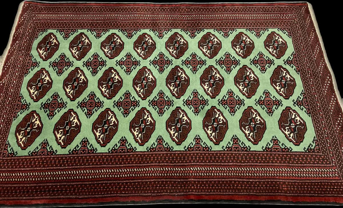 alfombra persa de estilo turcomana en dimensiones 198 centímetros de largo por 132 centímetros de ancho con colores principalmente verde — Perspectiva