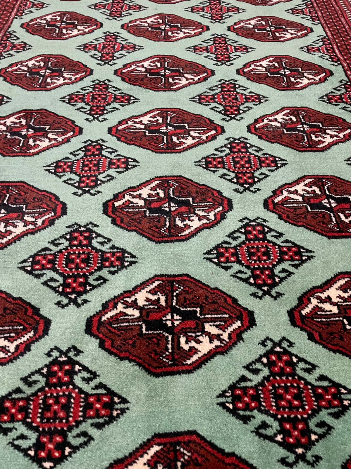 persischer Teppich im turkmenischer Stil in den Maßen 198 Zentimeter Länge mal 132 Zentimeter Breite mit überwiegend grün Farben — Nahaufnahme der Textur