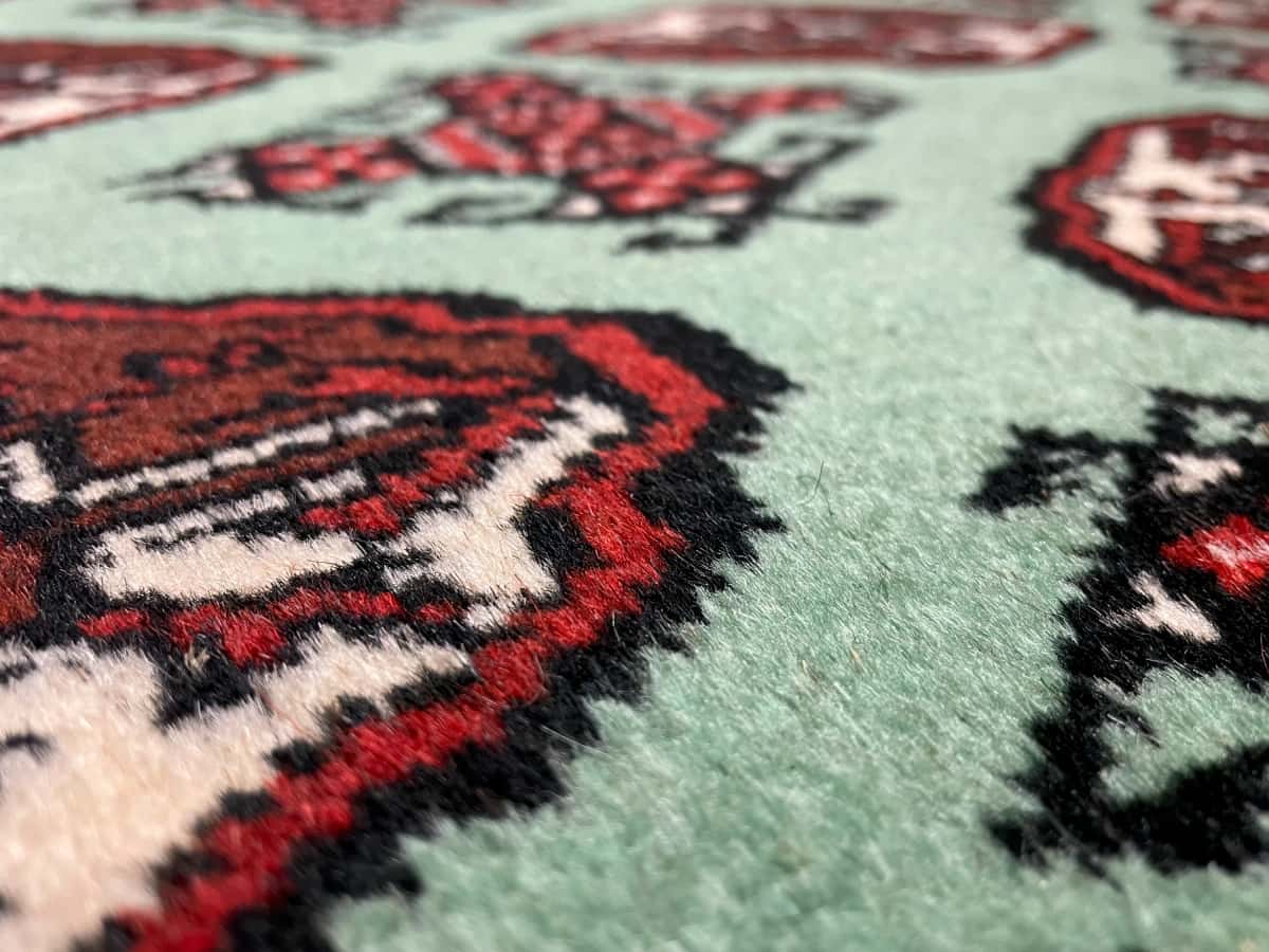 persischer Teppich im turkmenischer Stil in den Maßen 198 Zentimeter Länge mal 132 Zentimeter Breite mit überwiegend grün Farben — Nahaufnahme der Textur