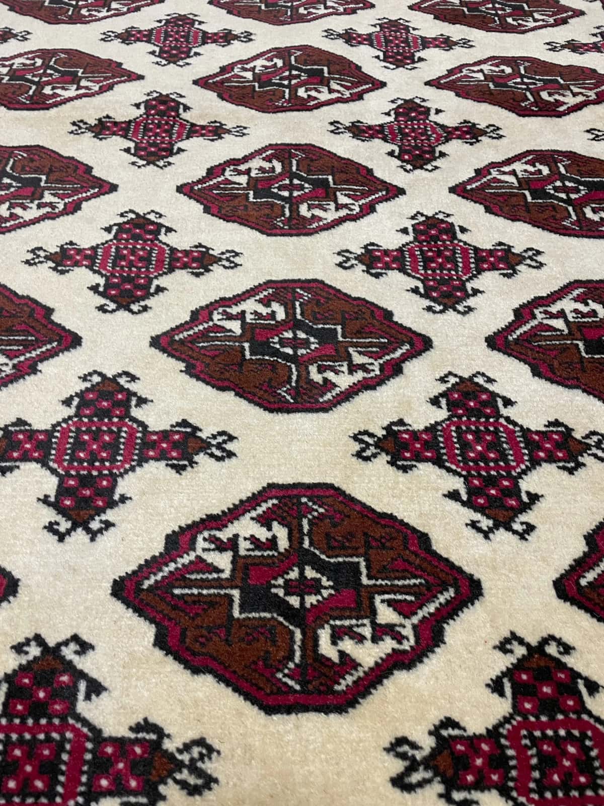 Persian rug in dimensions 190 centimeters length by 132 centimeters width with mainly red and beige colors — Texture close-up