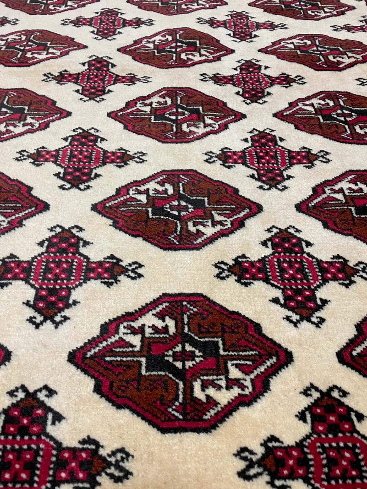 persischer Teppich in den Maßen 190 Zentimeter Länge mal 132 Zentimeter Breite mit überwiegend rot und beige Farben — Nahaufnahme der Textur