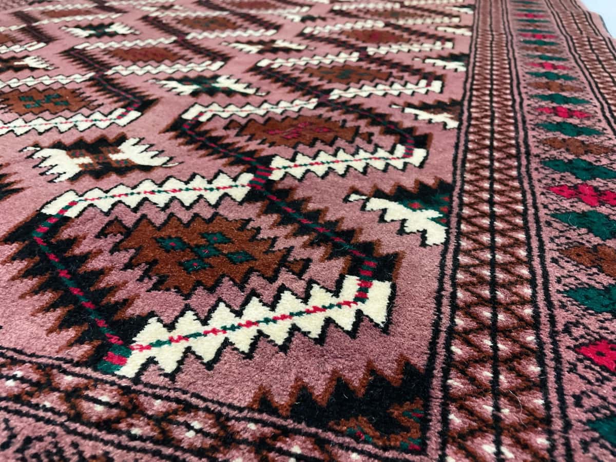 Persian rug in dimensions 190 centimeters length by 132 centimeters width with mainly red and beige colors — Texture close-up