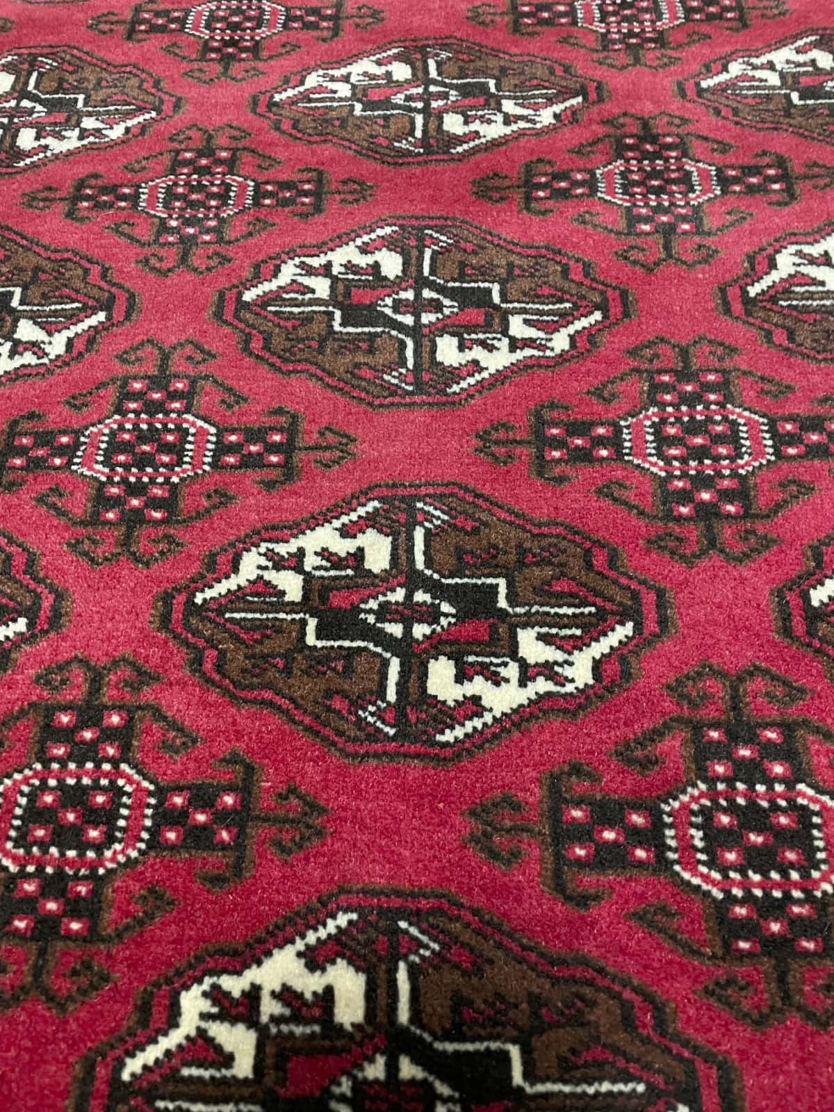 Persian rug of Turkoman style in dimensions 196 centimeters length by 135 centimeters width with mainly red colors — Texture close-up