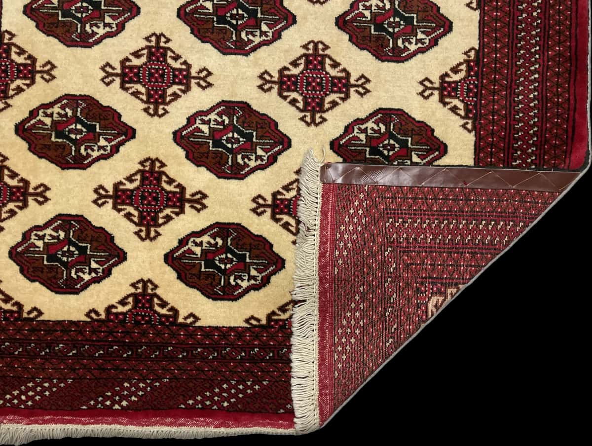 alfombra persa de estilo turcomana en dimensiones 190 centímetros de largo por 132 centímetros de ancho con colores principalmente beige — Plegada