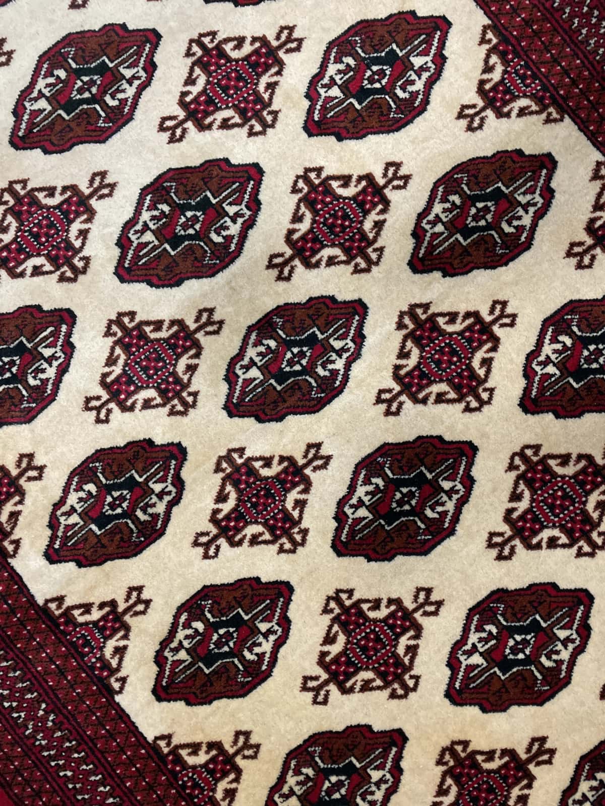 alfombra persa de estilo turcomana en dimensiones 190 centímetros de largo por 132 centímetros de ancho con colores principalmente beige — Primer plano de la textura