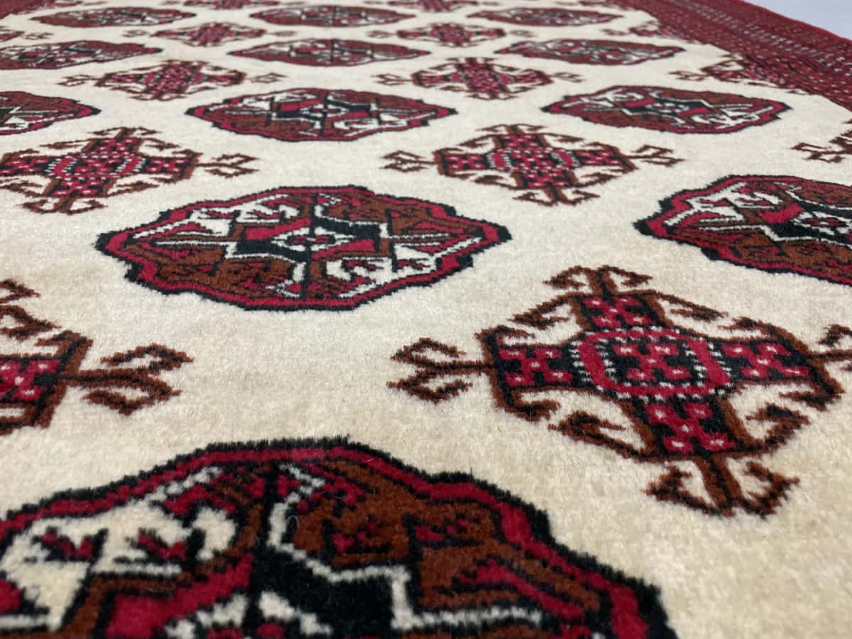 alfombra persa de estilo turcomana en dimensiones 190 centímetros de largo por 132 centímetros de ancho con colores principalmente beige — Primer plano de la textura