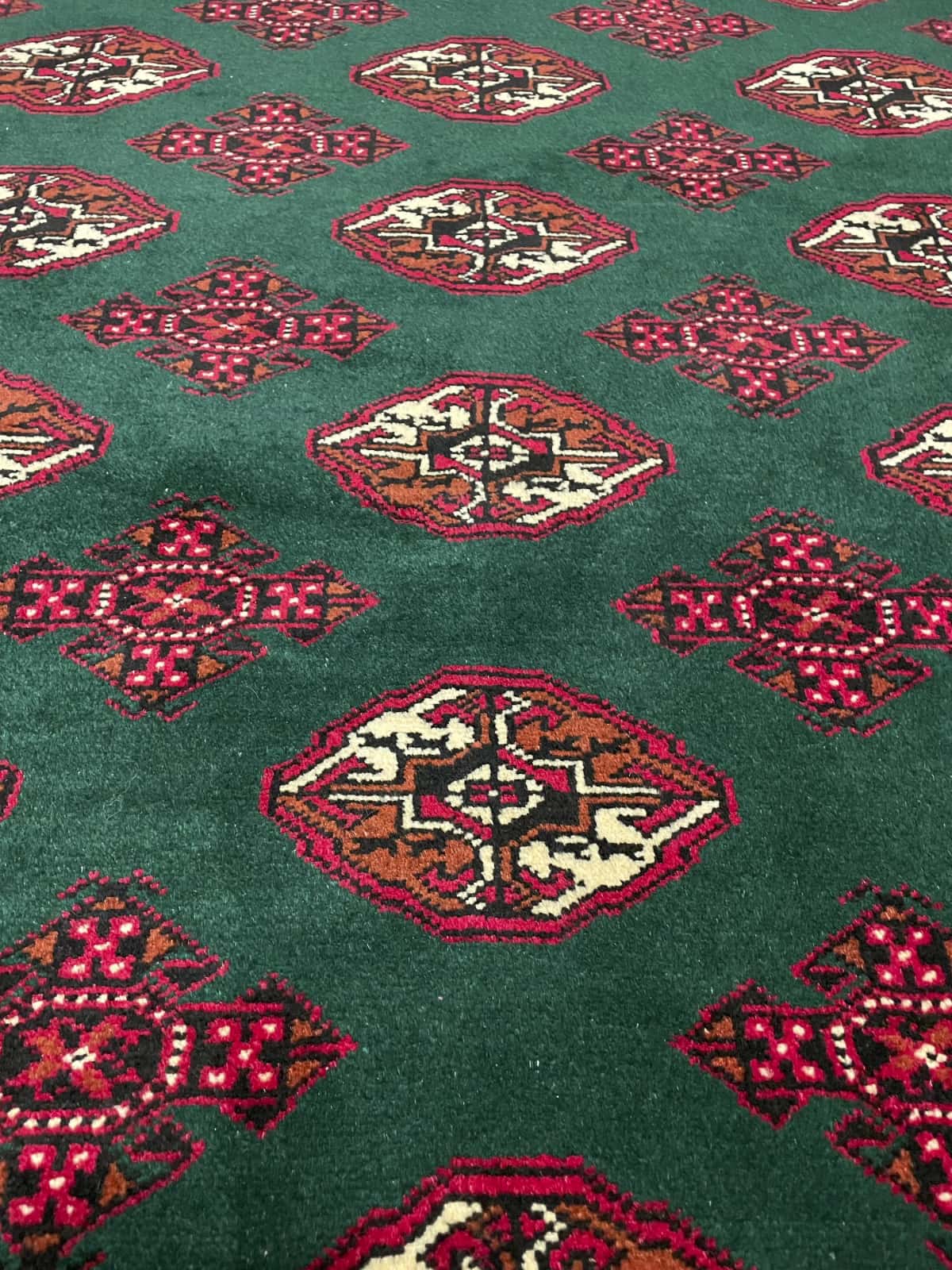 alfombra persa de estilo turcomana en dimensiones 196 centímetros de largo por 132 centímetros de ancho con colores principalmente verde — Primer plano de la textura