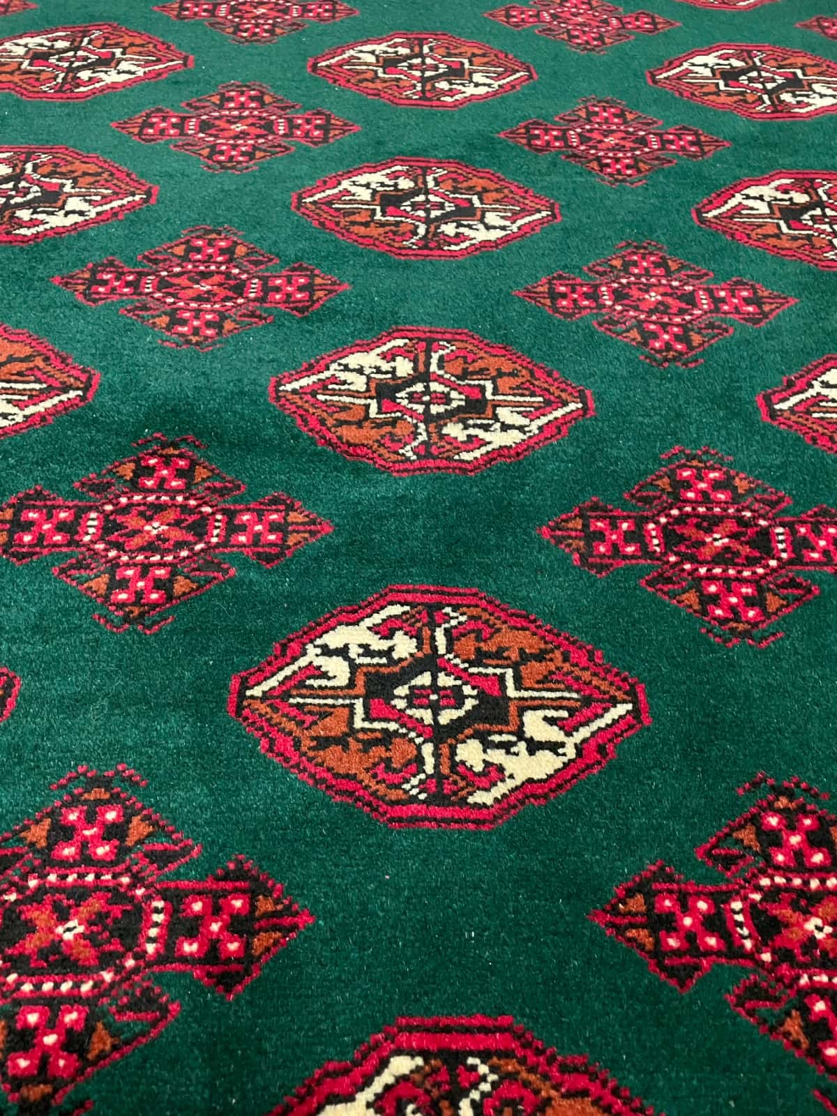 Persian rug of Turkoman style in dimensions 196 centimeters length by 132 centimeters width with mainly green colors — Texture close-up