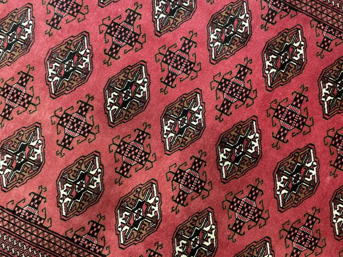 Persian rug of Turkoman style in dimensions 193 centimeters length by 136 centimeters width with mainly red colors — Texture close-up