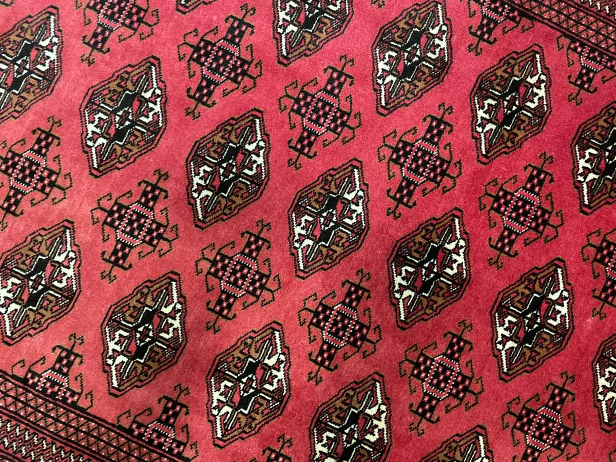 persischer Teppich im turkmenischer Stil in den Maßen 193 Zentimeter Länge mal 136 Zentimeter Breite mit überwiegend rot Farben — Nahaufnahme der Textur