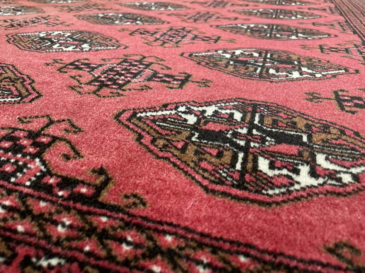 Persian rug of Turkoman style in dimensions 193 centimeters length by 136 centimeters width with mainly red colors — Texture close-up