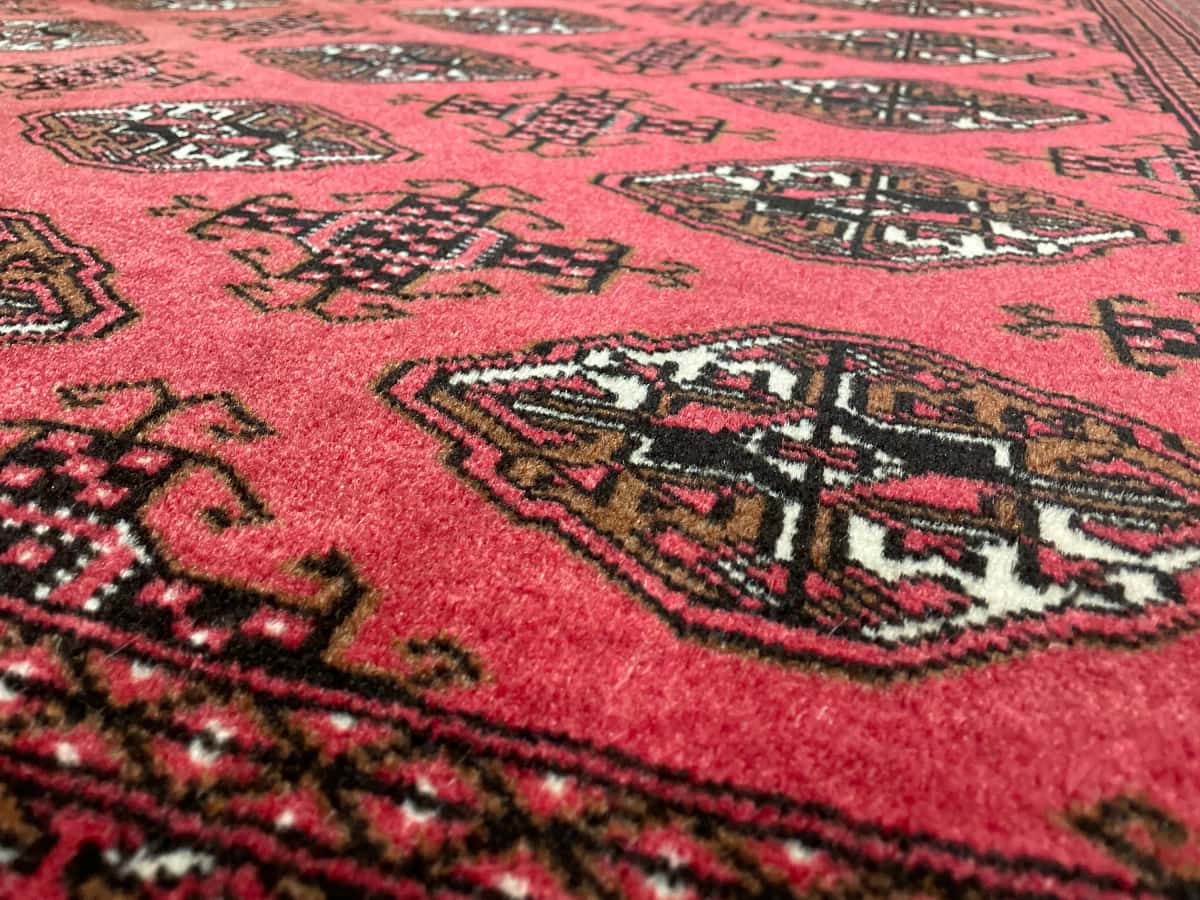 persischer Teppich im turkmenischer Stil in den Maßen 193 Zentimeter Länge mal 136 Zentimeter Breite mit überwiegend rot Farben — Nahaufnahme der Textur
