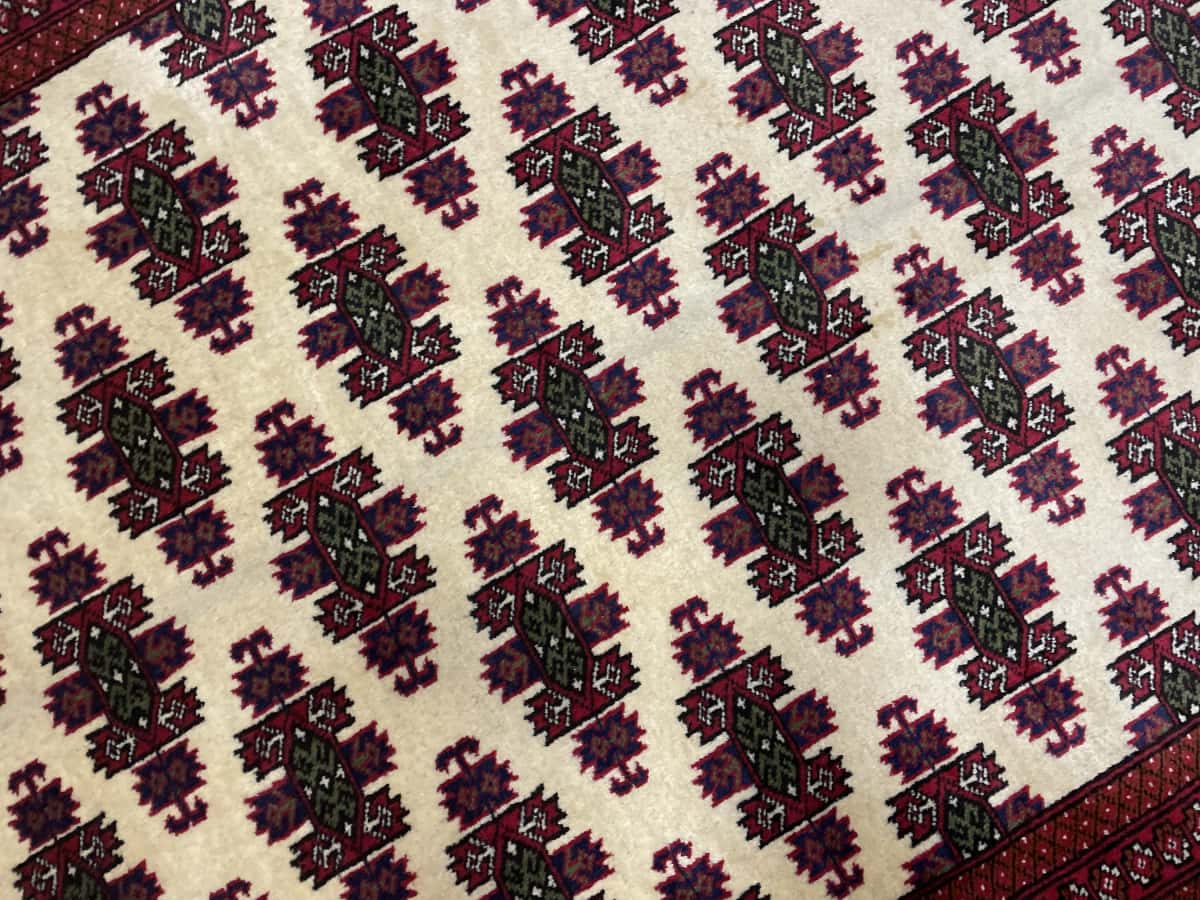 Persian rug of Turkoman style in dimensions 185 centimeters length by 132 centimeters width with mainly red and beige colors — Texture close-up