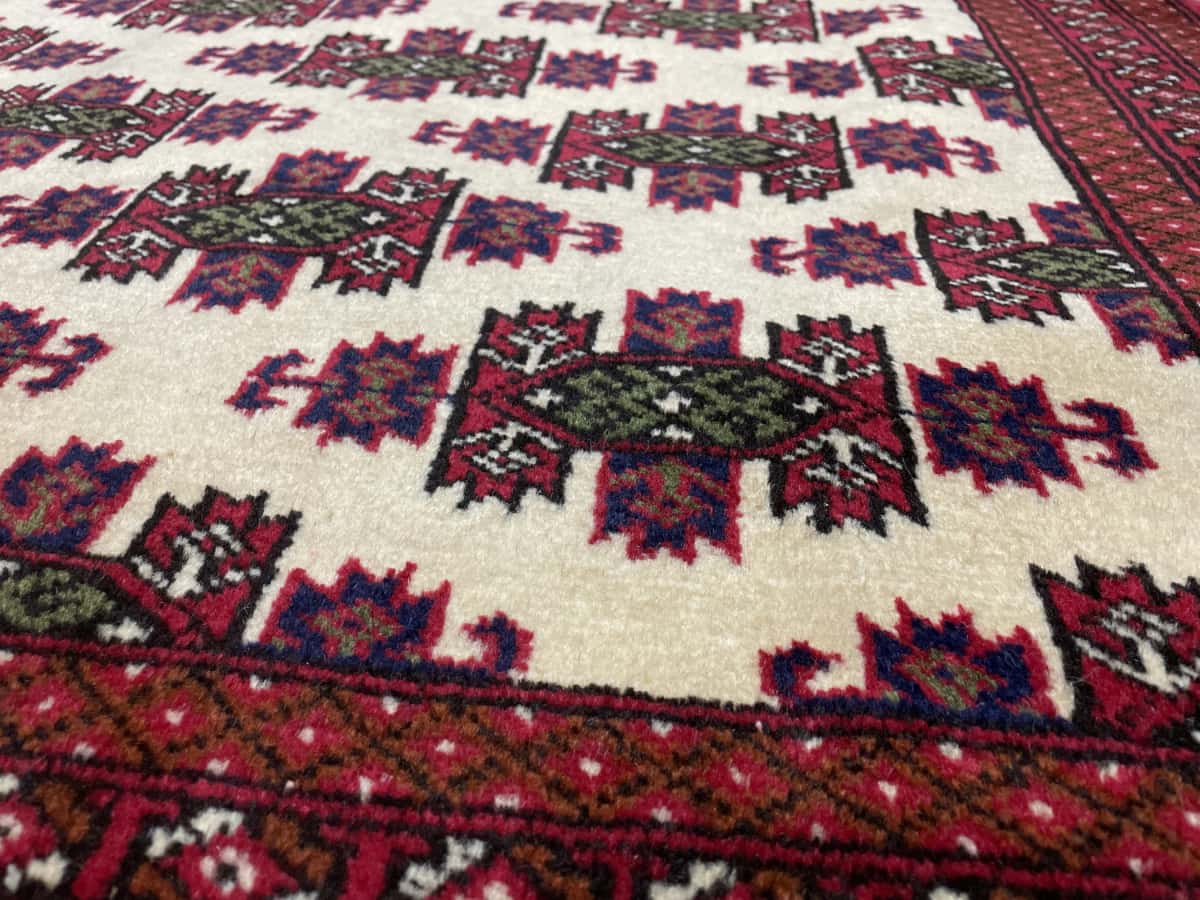 Persian rug of Turkoman style in dimensions 185 centimeters length by 132 centimeters width with mainly red and beige colors — Texture close-up