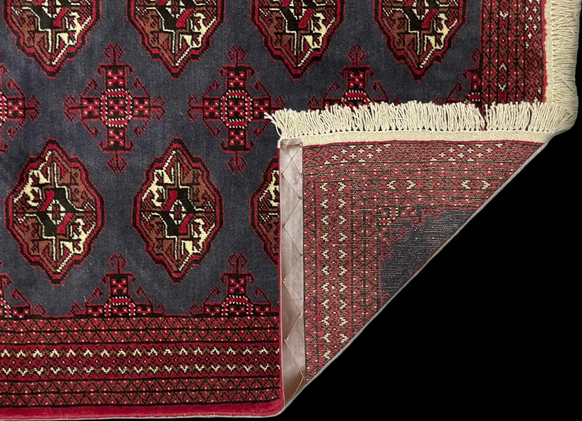 Persian rug of Turkoman style in dimensions 179 centimeters length by 130 centimeters width with mainly red and blue colors — Folded