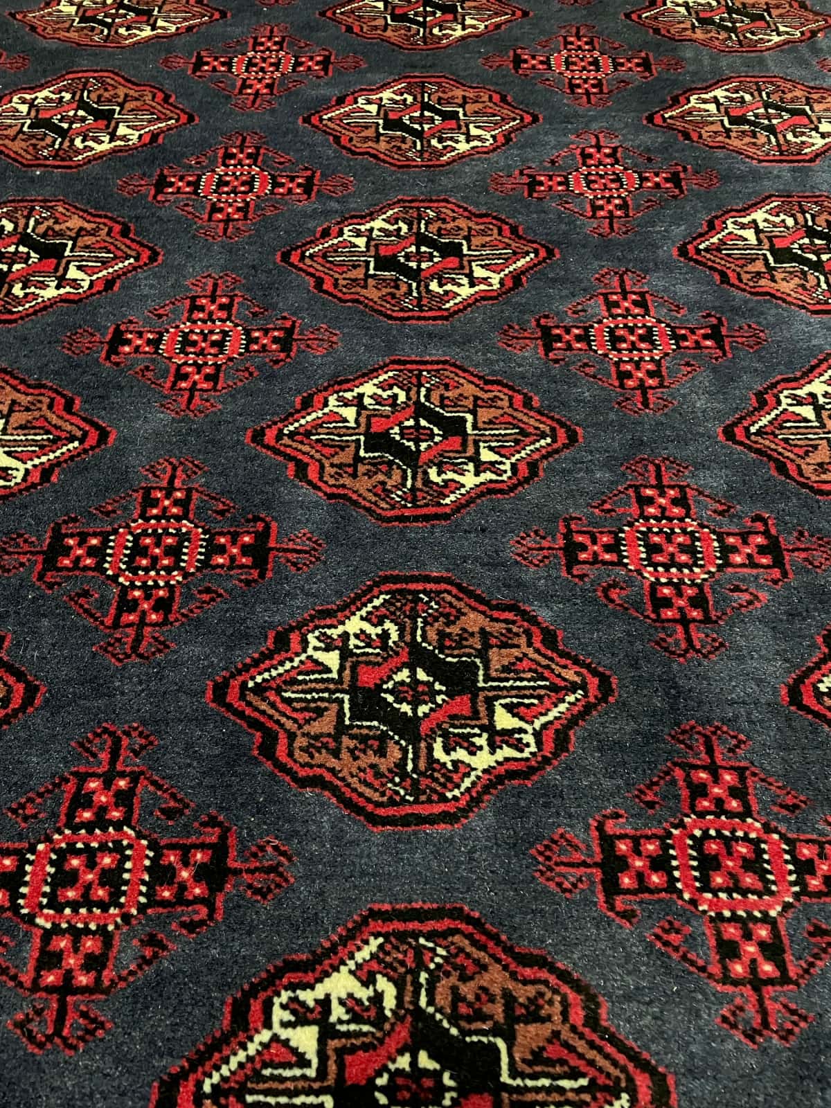 persischer Teppich im turkmenischer Stil in den Maßen 179 Zentimeter Länge mal 130 Zentimeter Breite mit überwiegend rot und blau Farben — Perspektive