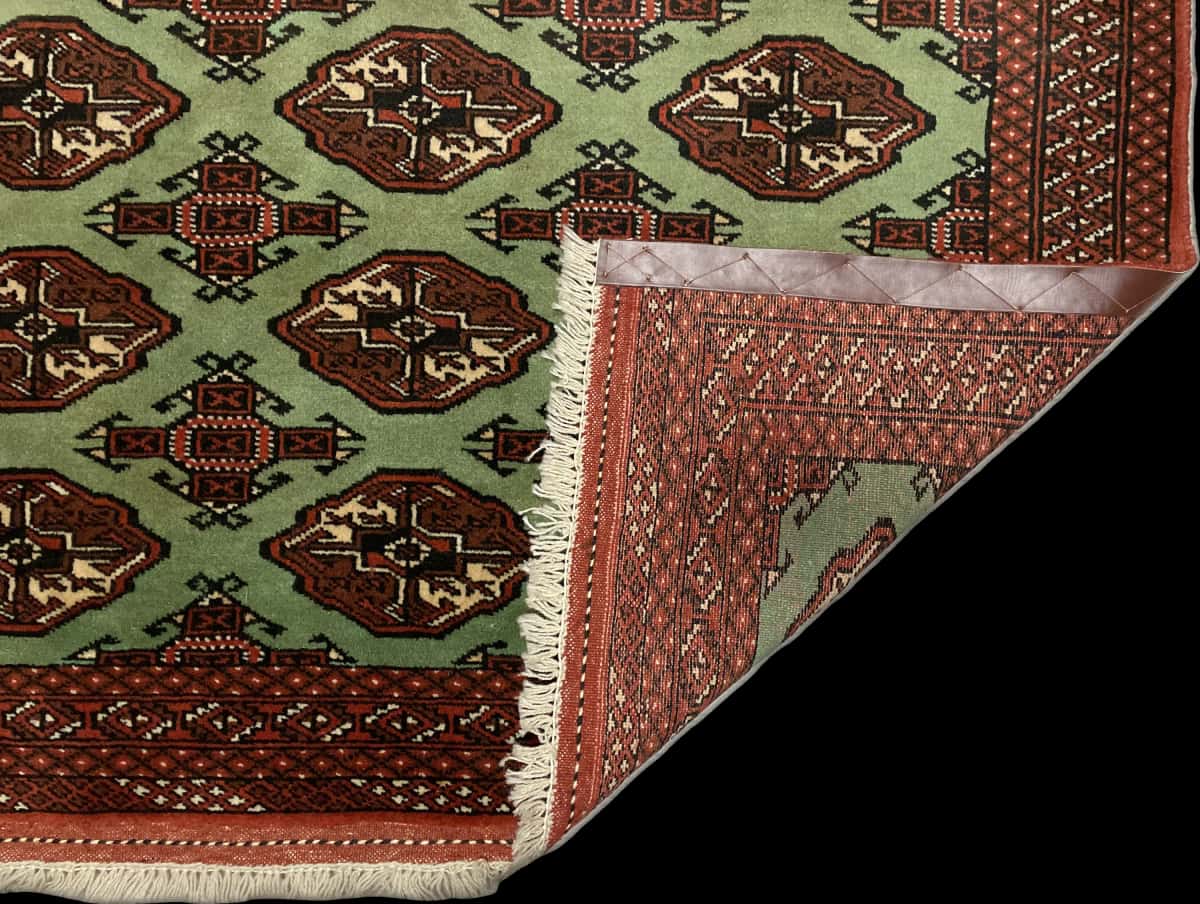 alfombra persa de estilo turcomana en dimensiones 188 centímetros de largo por 130 centímetros de ancho con colores principalmente verde — Plegada
