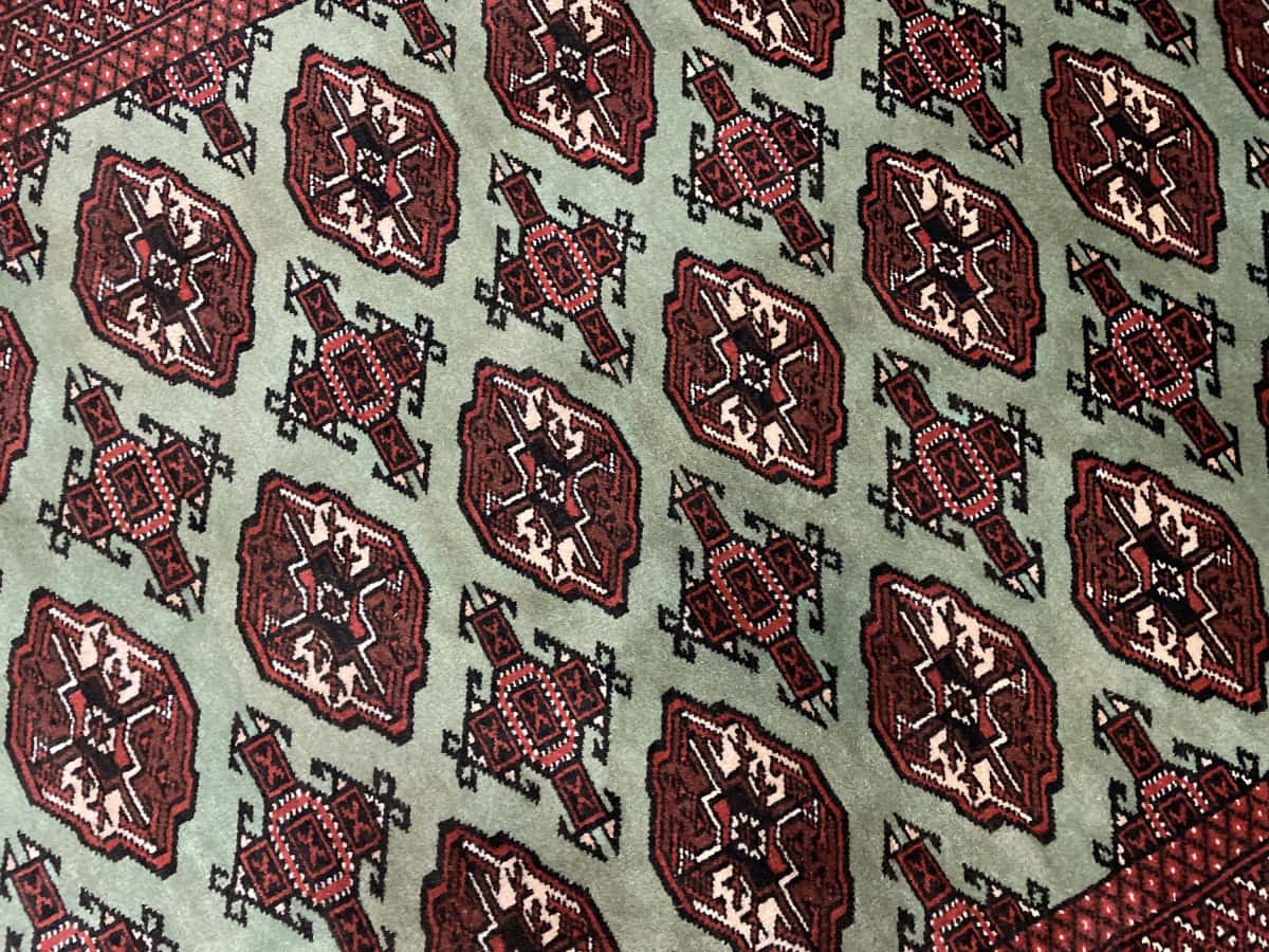 alfombra persa de estilo turcomana en dimensiones 188 centímetros de largo por 130 centímetros de ancho con colores principalmente verde — Primer plano de la textura