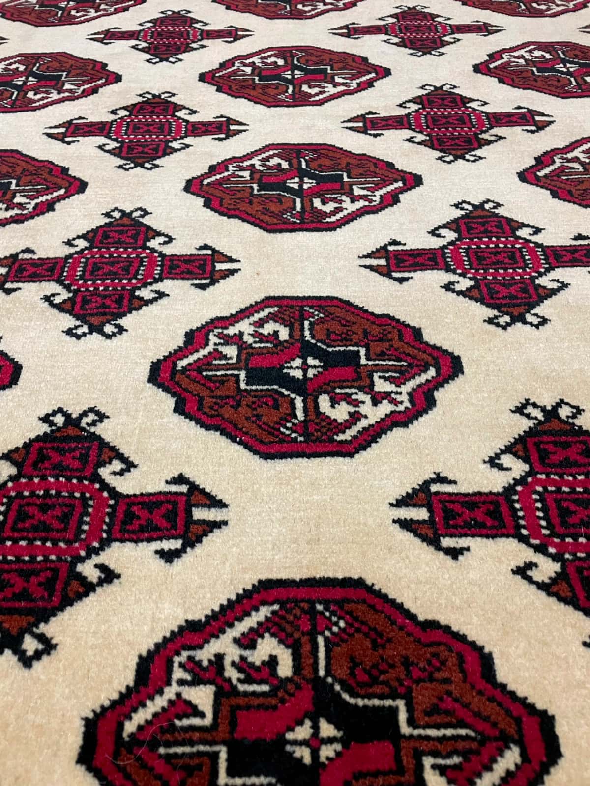 persischer Teppich im turkmenischer Stil in den Maßen 196 Zentimeter Länge mal 136 Zentimeter Breite mit überwiegend beige und rot Farben — Nahaufnahme der Textur