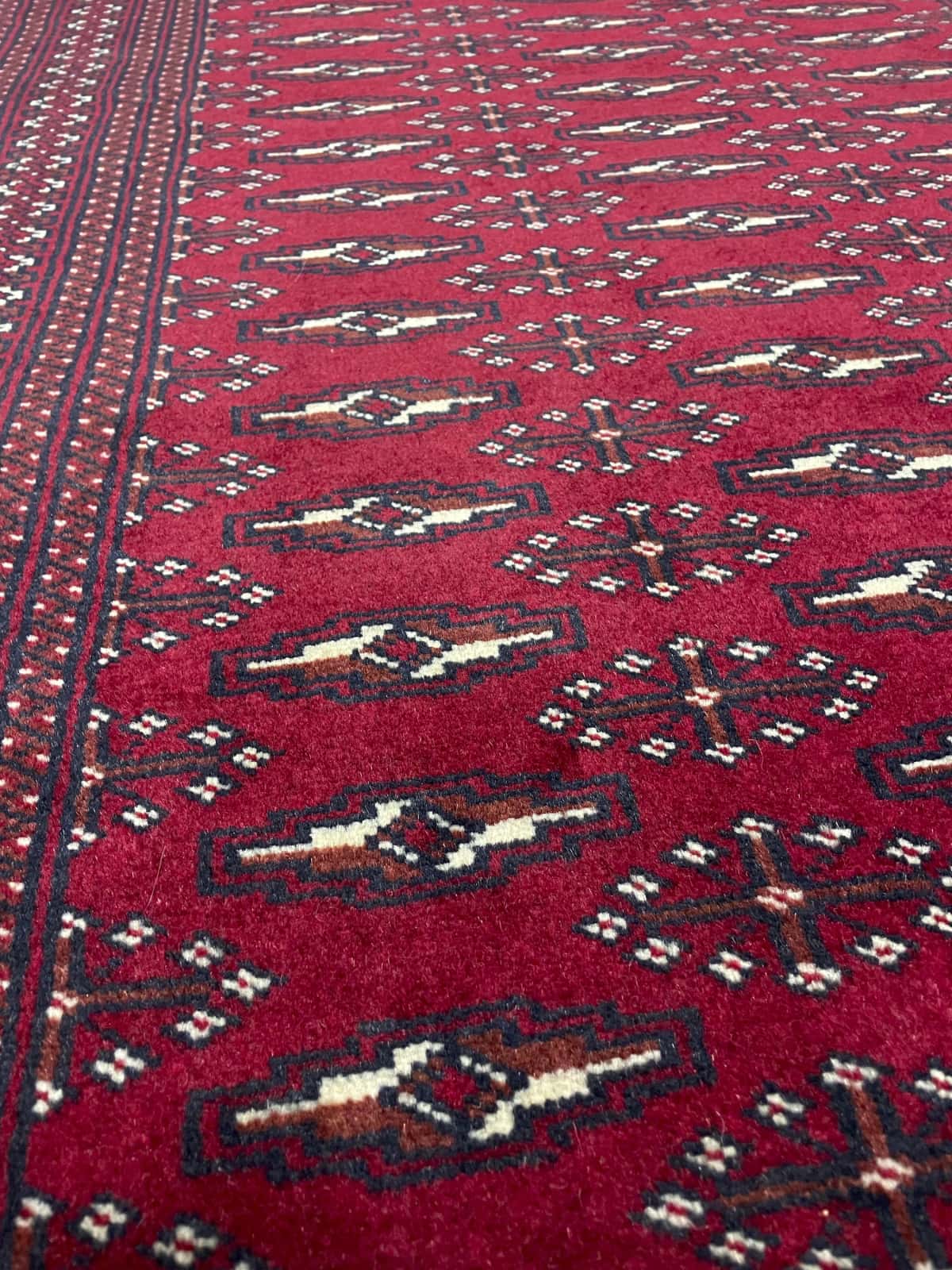 Persian rug of Turkoman style in dimensions 200 centimeters length by 102 centimeters width with mainly red colors — Texture close-up