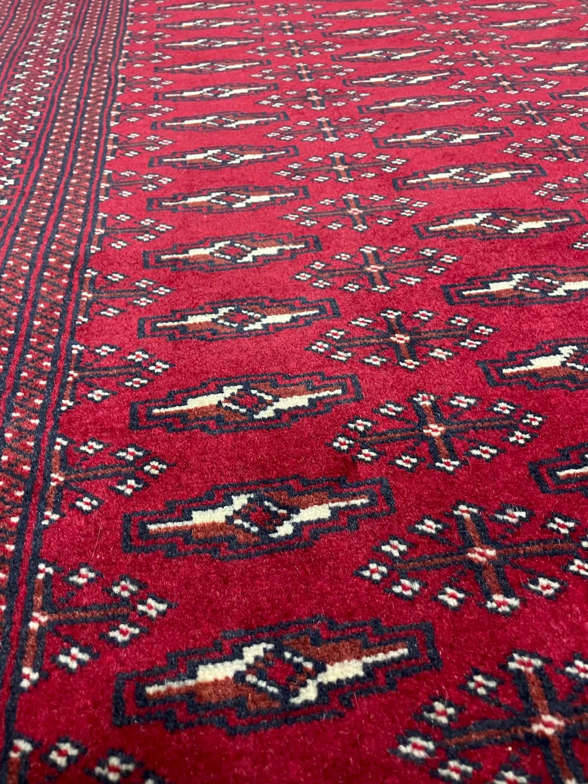 persischer Teppich im turkmenischer Stil in den Maßen 200 Zentimeter Länge mal 102 Zentimeter Breite mit überwiegend rot Farben — Nahaufnahme der Textur