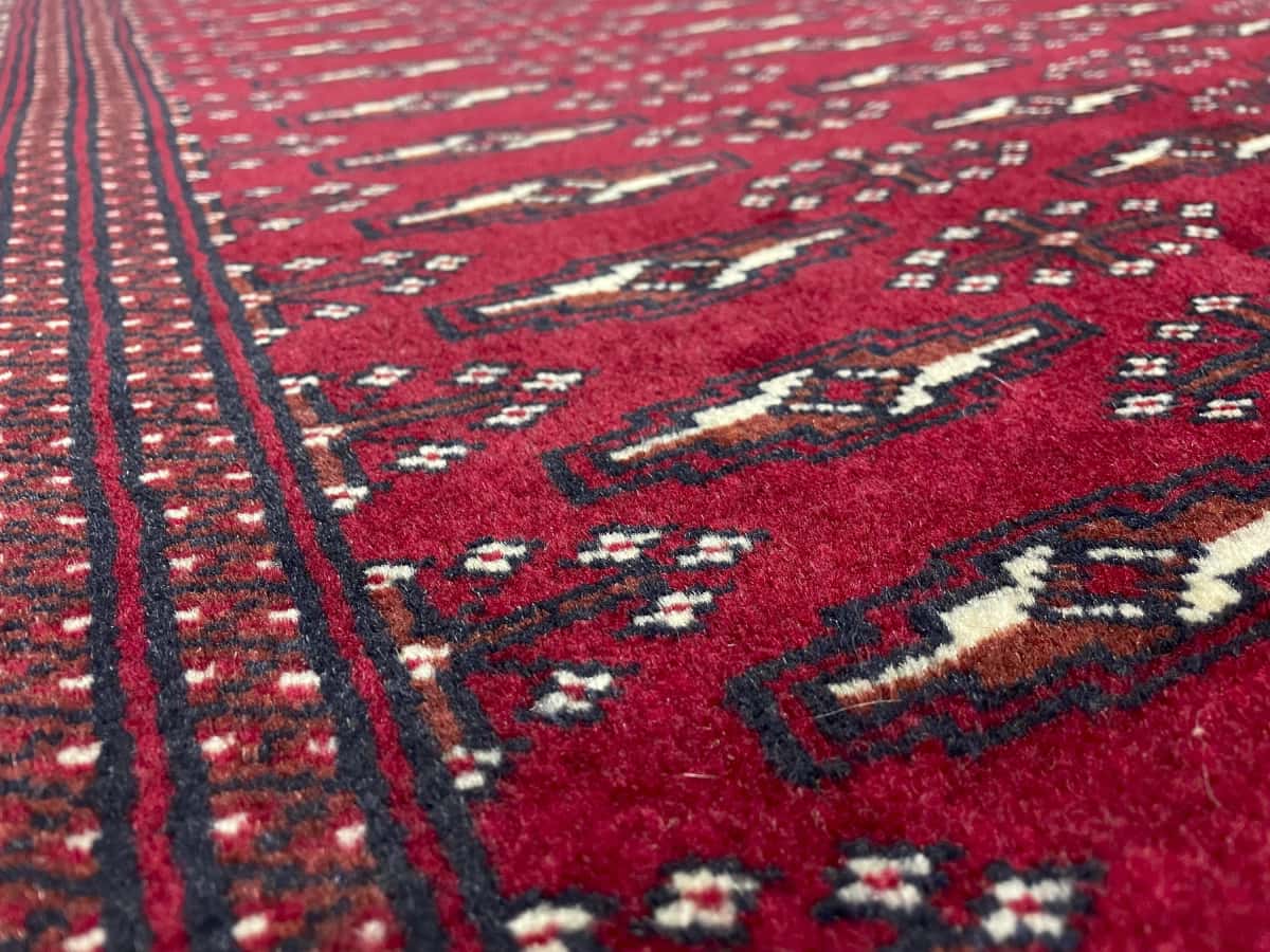 Persian rug of Turkoman style in dimensions 200 centimeters length by 102 centimeters width with mainly red colors — Texture close-up