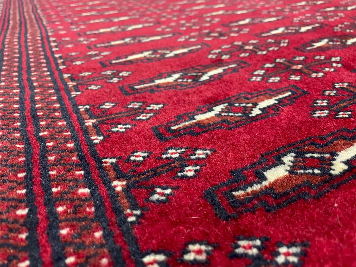 persischer Teppich im turkmenischer Stil in den Maßen 200 Zentimeter Länge mal 102 Zentimeter Breite mit überwiegend rot Farben — Nahaufnahme der Textur