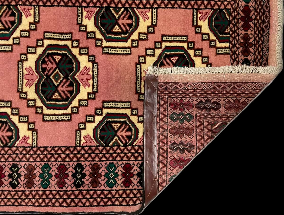 persischer Teppich im turkmenischer Stil in den Maßen 125 Zentimeter Länge mal 85 Zentimeter Breite mit überwiegend rosa Farben — Gefaltet