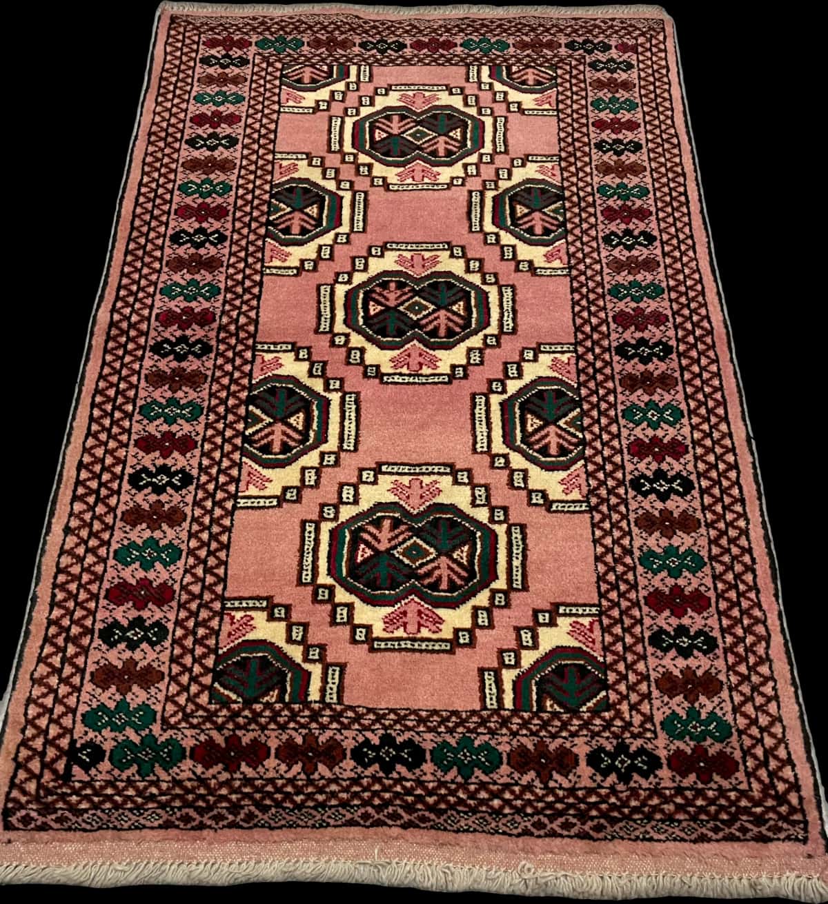 persischer Teppich im turkmenischer Stil in den Maßen 125 Zentimeter Länge mal 85 Zentimeter Breite mit überwiegend rosa Farben — Perspektive